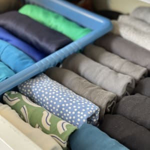 חולצות מקופלות במגירה עם מחיצה כחולה