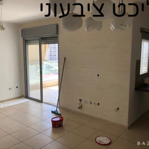 דלי צבע ומגב על רצפת חדר