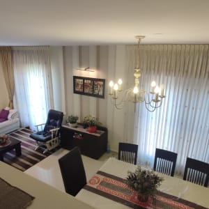 וילונות בהירים וארוכים ליד שולחן אוכל