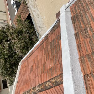 גג רעפים אדומים עם קיר לבן במרכז