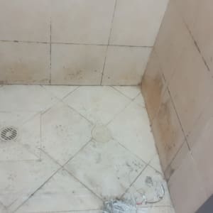 רצפת מקלחת עם אריחים מלוכלכים וניקוז