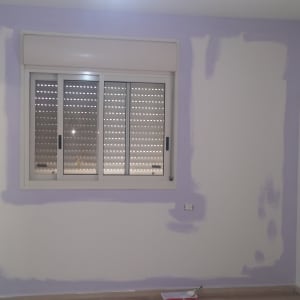 קיר צבוע חלקית בצבע סגול בהיר עם חלון