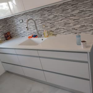 כיור מטבח עם ברז, בקבוק תינוק וכוס חד פעמית