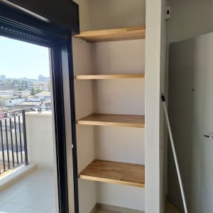 מדפים מעץ במטבח ליד חלון גדול