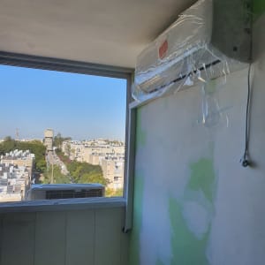 מזגן מותקן על קיר עם כיסוי פלסטיק שקוף