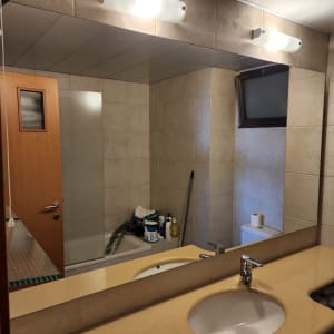 מראה גדולה מעל כיור בחדר אמבטיה