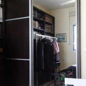 ארון עץ עם דלתות הזזה ומדפי ספרים