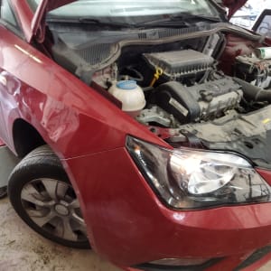 מכונית אדומה עם מכסה מנוע פתוח במוסך