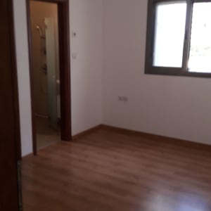 חדר ריק עם קירות לבנים ורצפת עץ