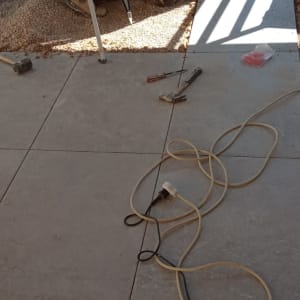 אדם עובד על רצפה עם כלים וחצץ