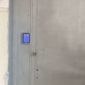 לוח מקשים כחול על דלת מתכת אפורה