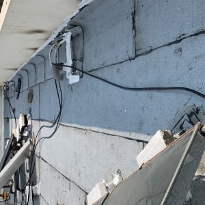 איטום גג עם חומר לבן סביב צינורות וכבלים