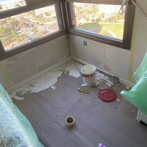 חדר בשיפוץ עם קירות מתקלפים, דלי צבע וכלי עבודה