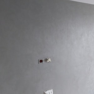 קיר צבוע באפור עם דלי צבע אדום על הרצפה