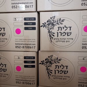 קופסאות קרטון עם מדבקות ורודות ופרטי התקשרות