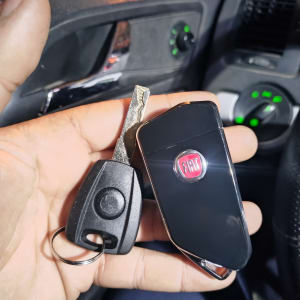 מפתח רכב ושלט פיאט ביד בתוך רכב