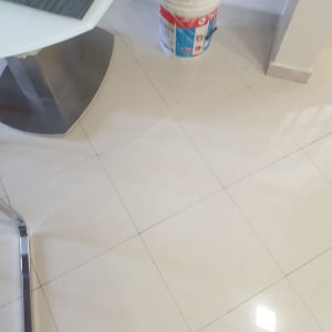 דלי צבע על רצפה מרוצפת ליד שולחן