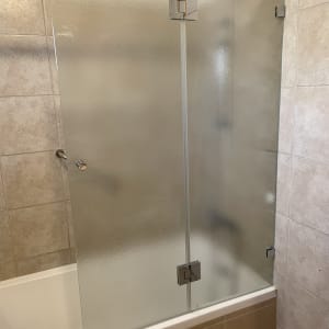 דלת זכוכית חלבית במקלחת עם אריחי קרמיקה