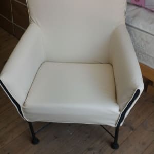 כורסה מרופדת בלבן עם רגלי מתכת שחורות