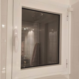 חלון אלומיניום לבן עם ידית בחדר אמבטיה