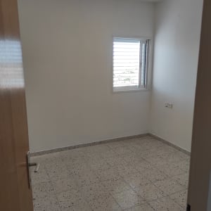 חדר ריק עם חלון ותריסים פתוחים