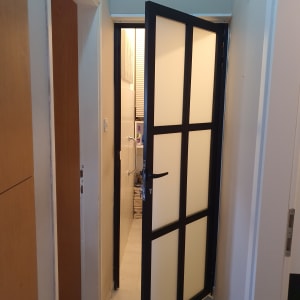 דלת אלומיניום עם מסגרת שחורה וזכוכית חלבית