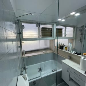 מקלחת עם דלת זכוכית, ראש מקלחת ומוצרי טיפוח