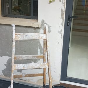סולם עץ מול קיר בטון בתהליך שיפוץ