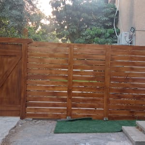 גדר עץ חומה עם שער ליד מדרגות אבן