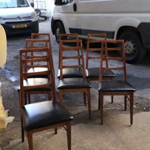 שמונה כיסאות עץ עם ריפוד שחור בחוץ