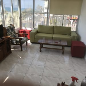 חלון עם וילון גלילה בהיר בחדר שמש