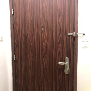 דלת עץ עם ידית מתכת ובריח בטיחות