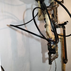 צינורות ומחברים על קיר צבוע בלבן