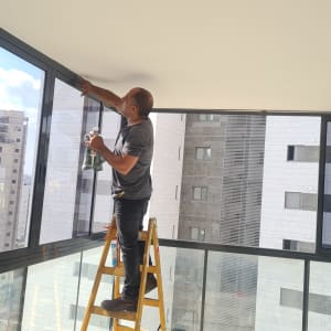 אדם עובד על מסגרת אלומיניום של חלון