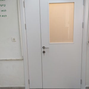 דלת לבנה עם חלון זכוכית ומנעול כסוף