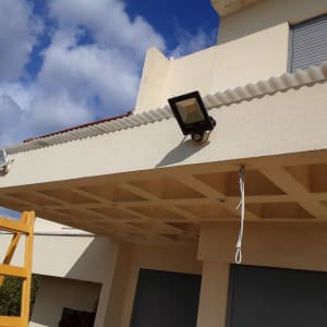 סולם עץ ליד פרגולה עם תאורה חיצונית