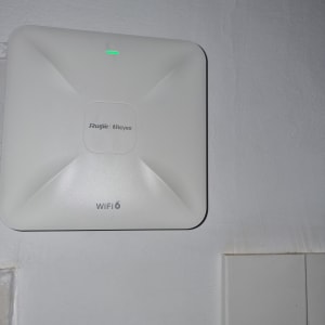 נתב WiFi 6 מותקן על קיר עם נורית ירוקה דולקת