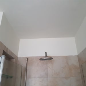 קיר ותקרה צבועים בלבן בחדר אמבטיה