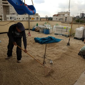 עובדים במהלך יישור תשתית והנחת אריחי ריצוף חוץ במרפסת