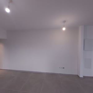 קיר גבס עם תאורה עליונה בחדר ריק