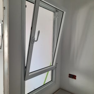 חלון אלומיניום פתוח עם מסגרת לבנה