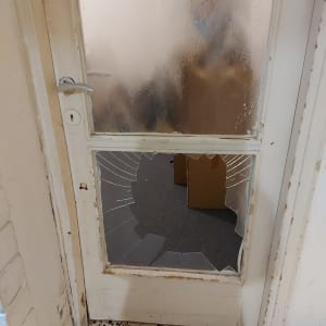 זכוכית שבורה בדלת עץ עם מסגרת לבנה