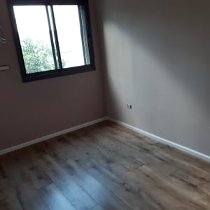 רצפת פרקט עץ בחדר עם קיר בהיר