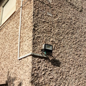 תאורת חוץ מותקנת על קיר עם חוטי חשמל