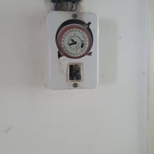 שעון טיימר חשמלי עם חוטים חשופים בקיר