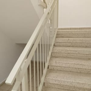 מדרגות עם מעקה צבוע בלבן