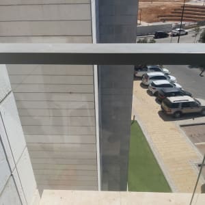 מעקה זכוכית עם מסגרת מתכת במרפסת