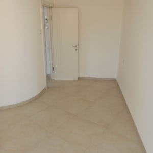 חדר ריק עם קירות לבנים ודלת פתוחה