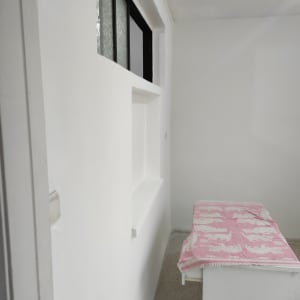 קיר צבוע בלבן עם חלון זכוכית קטן