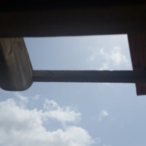 גג עץ עם קרש חסר בשמיים בהירים